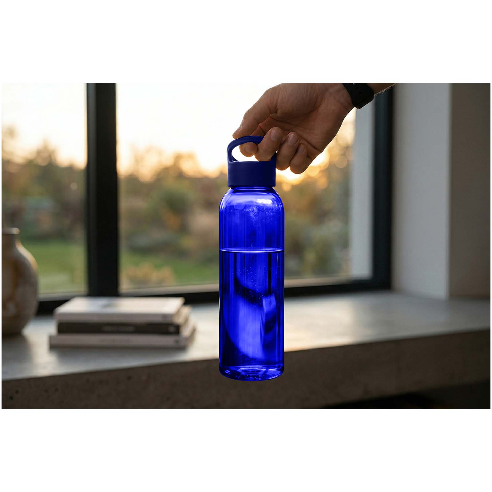 Blaue Tritan™ Sportflasche mit Griff, im Sonnenlicht gehalten.