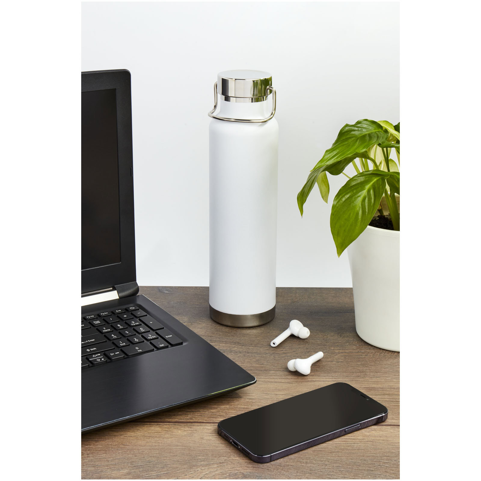 Weiße Isoliersportflasche mit Kupfer-Deckel auf Schreibtisch.