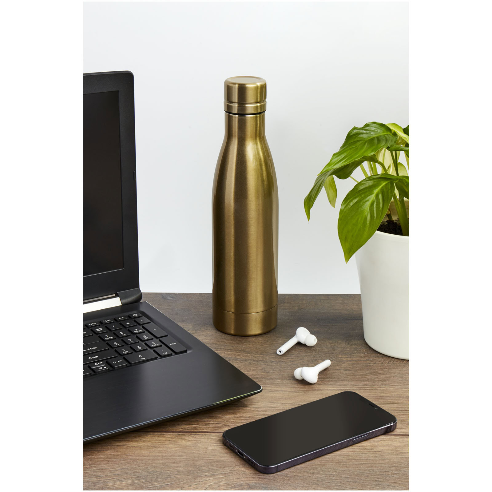 Kupfer-Vakuumflasche auf Schreibtisch mit Laptop und Smartphone.