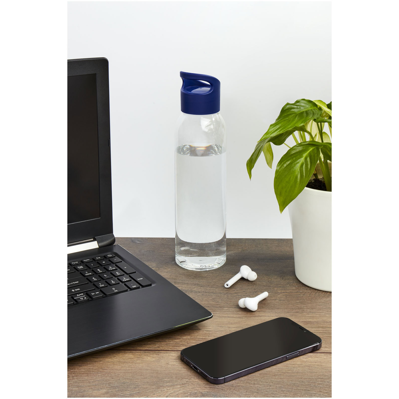Trinkflasche aus Tritan mit blauer Deckel auf Schreibtisch.